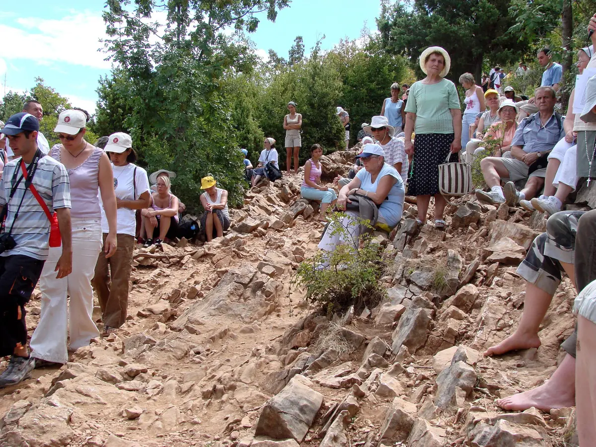 Pilgrims on a rocky hill path in Medjugorje
